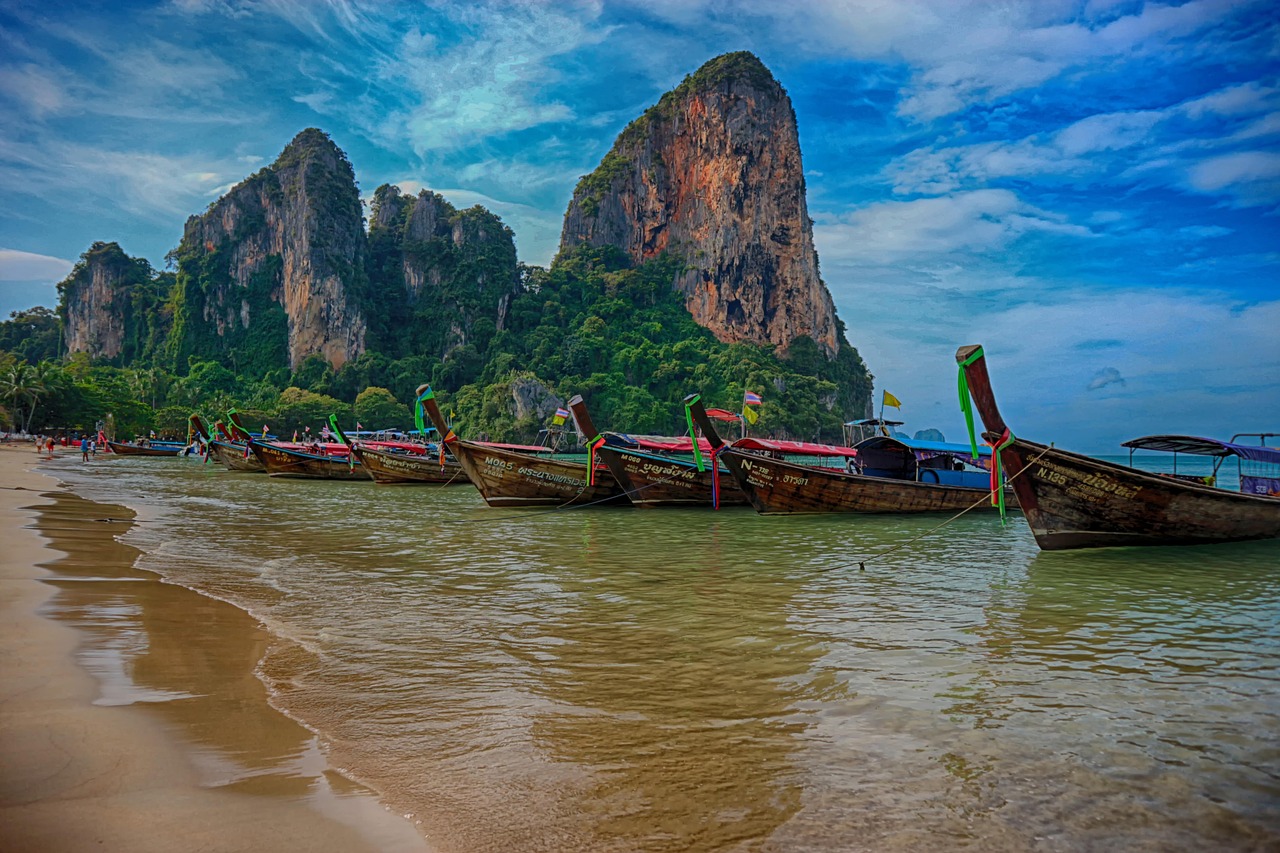 Bateaux traditionnels et falaises calcaires lors d’une excursion depuis Krabi en Thaïlande