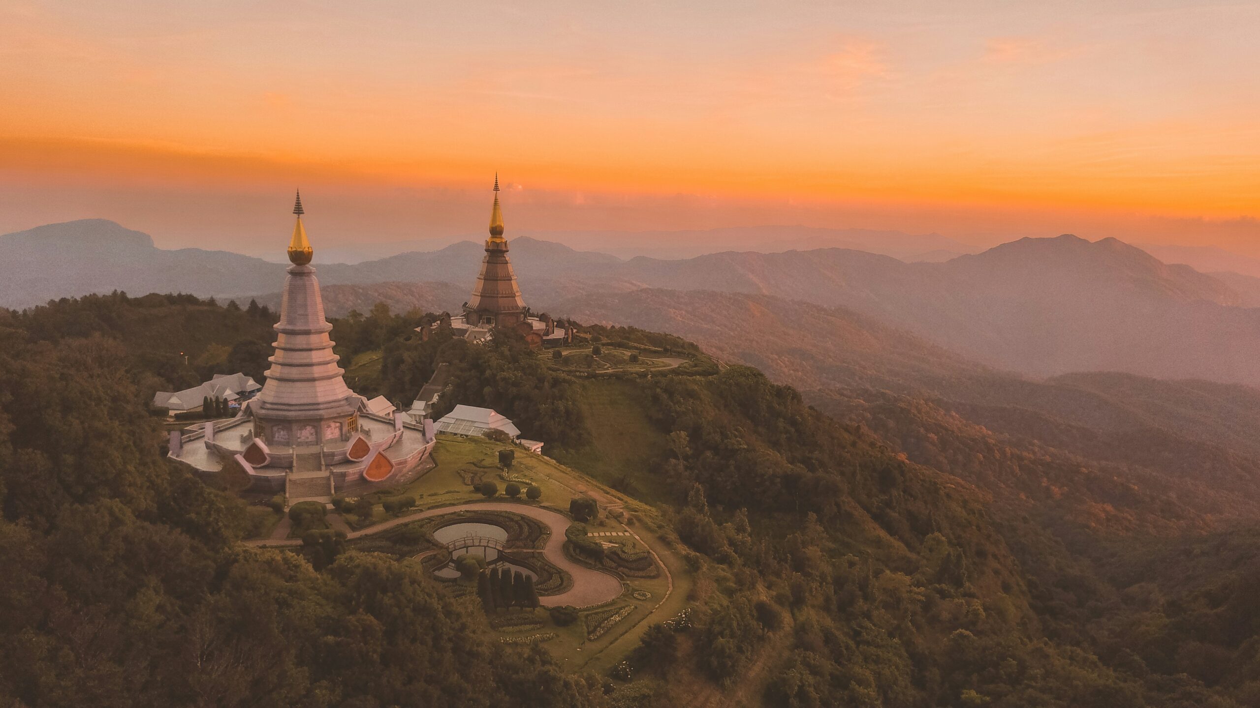 Temple bouddhiste de Chiang Mai au coucher du soleil, entouré de montagnes verdoyantes dans le nord de la Thaïlande